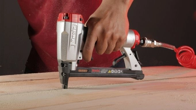 A man using Ronix RA-8016 on a wooden surface