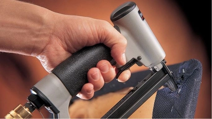  A man using a staple gun on fabric