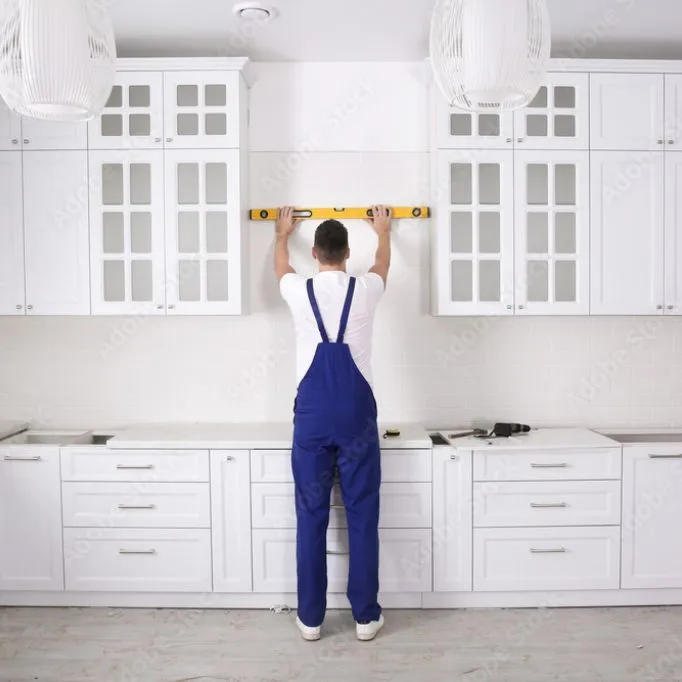 picture of a person with spirit level next to the cabinet 